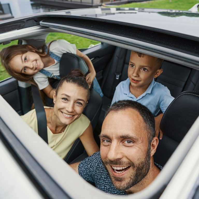 Family car travel Family smiling together in a car on a sunny day